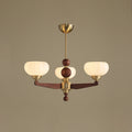 Three-light version of this Clérachic chandelier, with ribbed cream glass shades on wood arms, against a muted taupe backdrop.