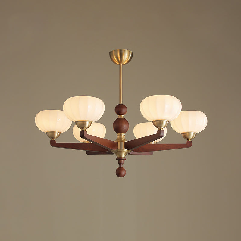 This Clérachic chandelier in its larger form, with six cream glass shades on turned wood arms, against a muted taupe backdrop.