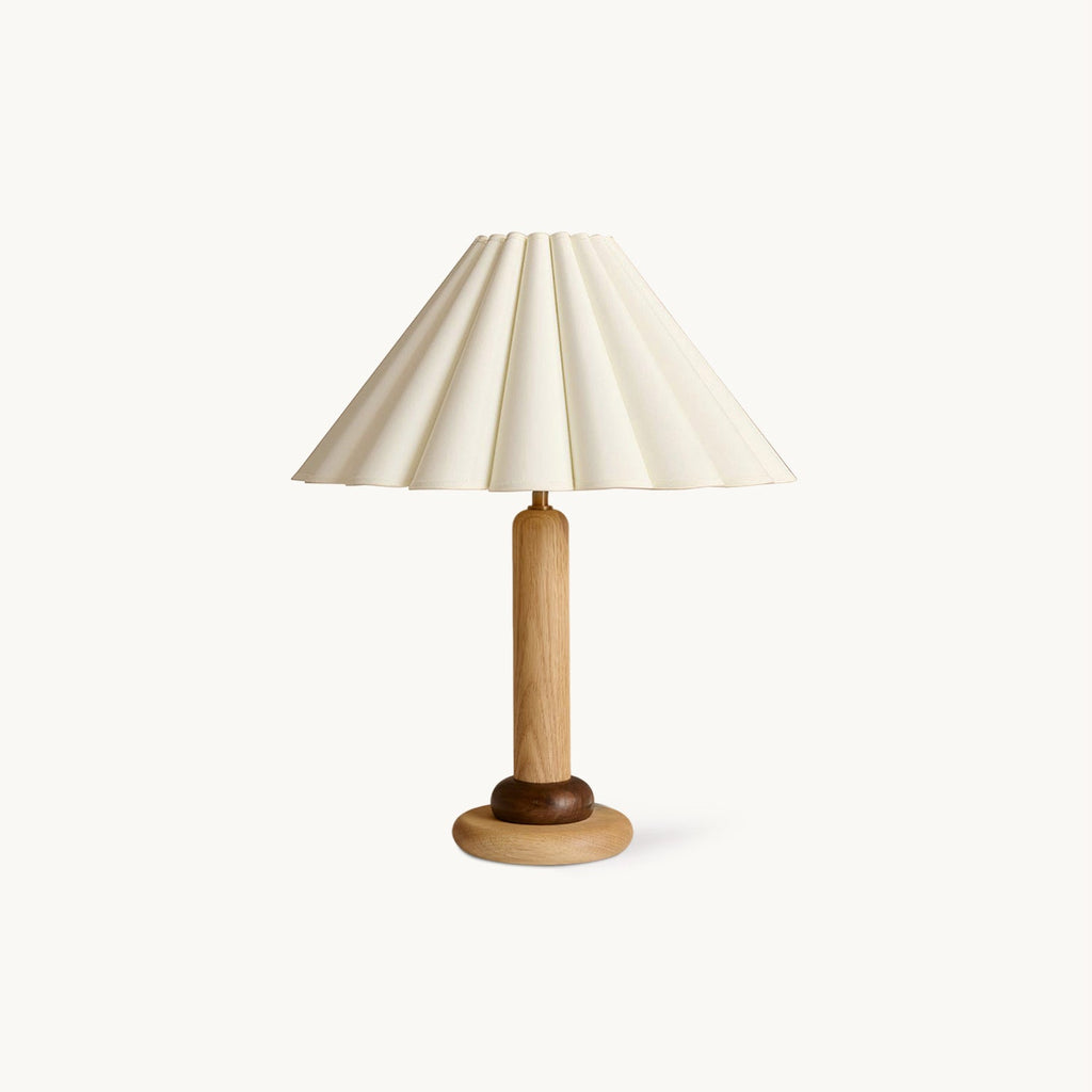 This Clérachic table lamp has a pleated cream shade on a slim wood stem and a rounded wooden base, shown on a plain white backdrop.