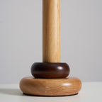 Close view of the base of this Clérachic table lamp, with a dark wood ring sitting on a rounded natural wood foot.