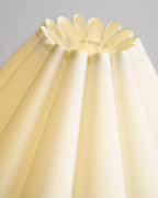 Looking up into the pleated cream shade of this Clérachic table lamp, where the fabric folds into a scalloped top rim.