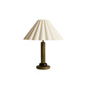 A Clérachic table lamp in a dark green wood stem and base, with a pleated cream shade, cut out on a white background.
