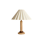 A Clérachic table lamp in natural light wood with a dark ring above the base and a pleated cream shade, on a white background.