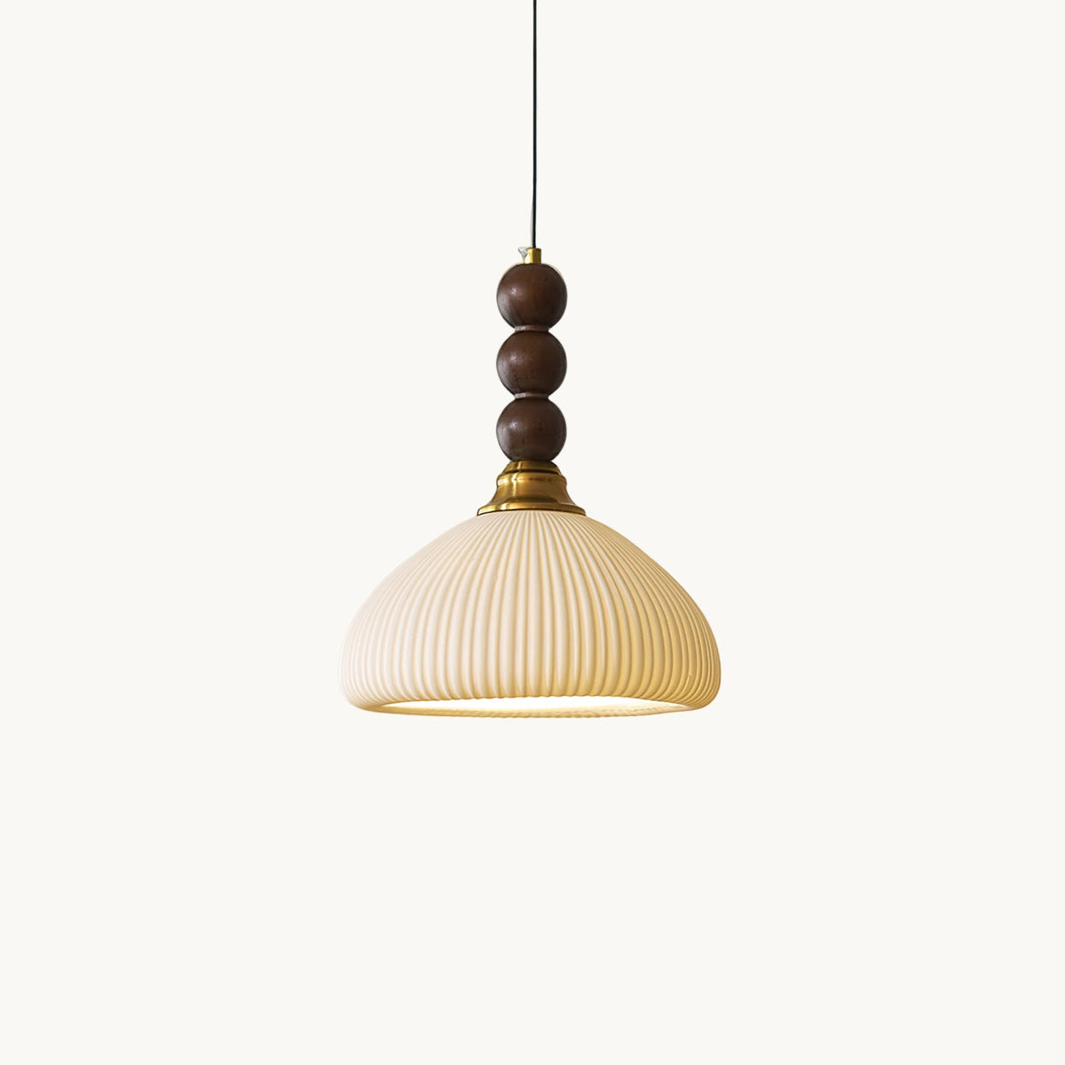 A Clérachic pendant with a ribbed cream ceramic shade and stacked walnut beads, on a plain white backdrop.