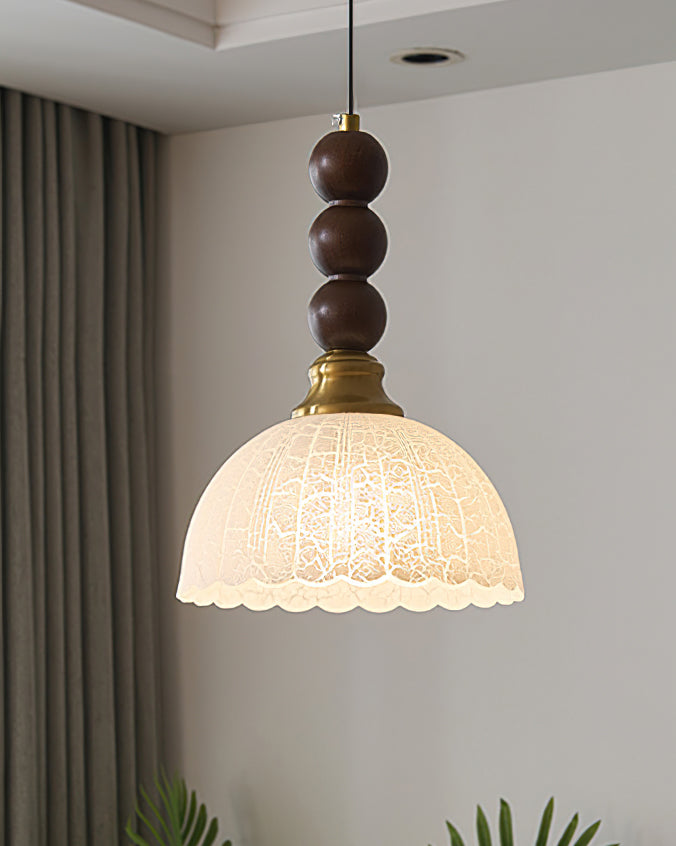 Seen against a grey curtain, this Clérachic pendant shows the crackle texture of its lit frosted dome shade.
