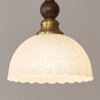 Close view of the frosted, scalloped-edge glass shade and brass collar on this Clérachic pendant.