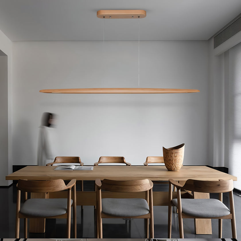Straight-on, a Clérachic beech pendant spans the width of a pale wood dining table with rattan-backed chairs.