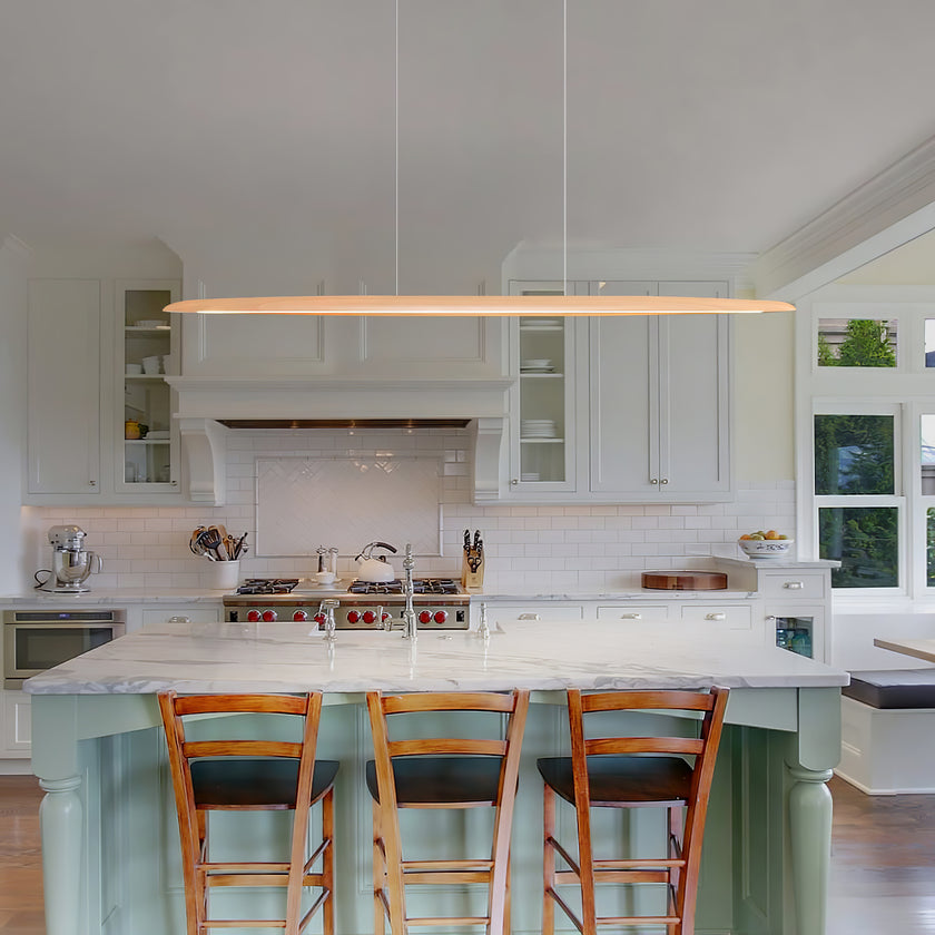 Hung over a pale-green kitchen island with three wooden stools, a Clérachic beech pendant runs the length of the island.