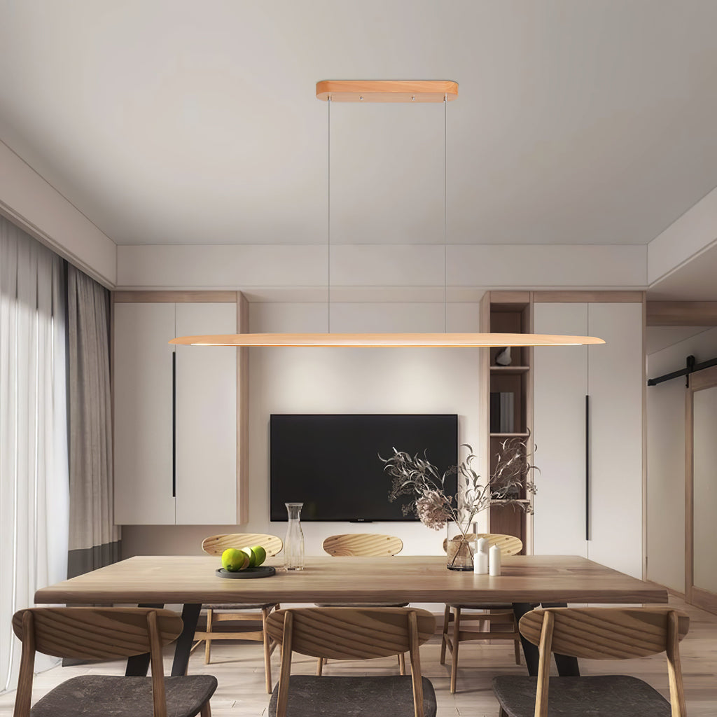In a modern dining room with a wall-mounted television, a Clérachic beech pendant spans a long timber table.