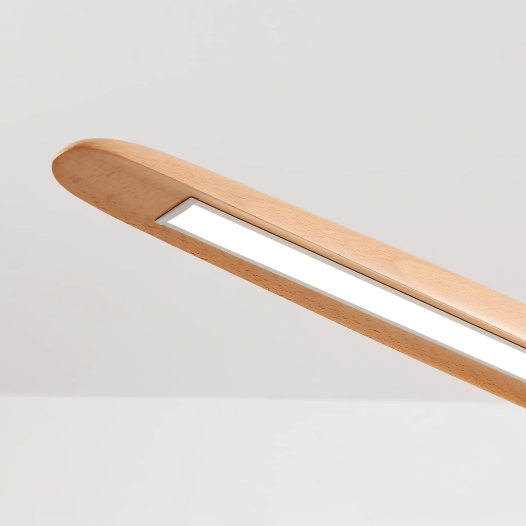 Close view of the rounded end of a beech Clérachic pendant, with its narrow light slot running along the underside.