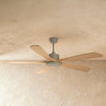 Clérachic ceiling fan with five pale wood blades and a grey downrod, motor housing and round light disc, on a textured plaster ceiling.