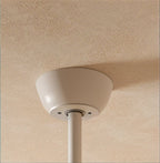 Clérachic fan's white ceiling canopy and slim white downrod fixed to a softly textured cream ceiling.