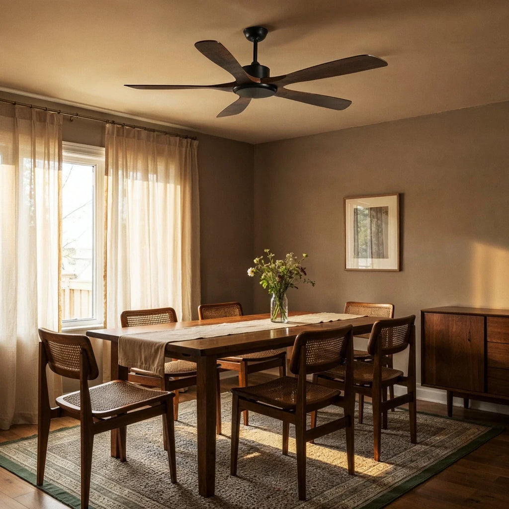 Clérachic five-blade ceiling fan with dark wood blades and a black motor above a dining table with cane chairs in warm evening light.
