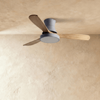 Clérachic low-profile ceiling fan in grey with three natural wood blades, the round LED light panel switched off.