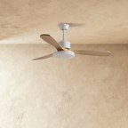 Clérachic ceiling fan on a short white downrod with three pale wood blades, the round LED light panel switched off.