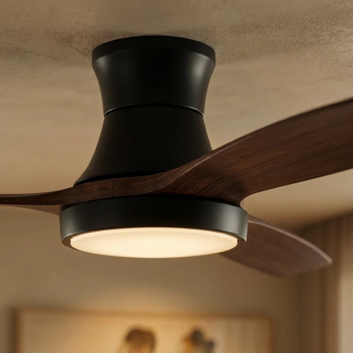 Close view of a Clérachic black low-profile ceiling fan, showing its curved motor housing, walnut-toned blade and glowing LED ring.