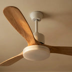 Close view from below of a Clérachic white downrod ceiling fan, showing broad wood-grain blades and the round frosted LED light.