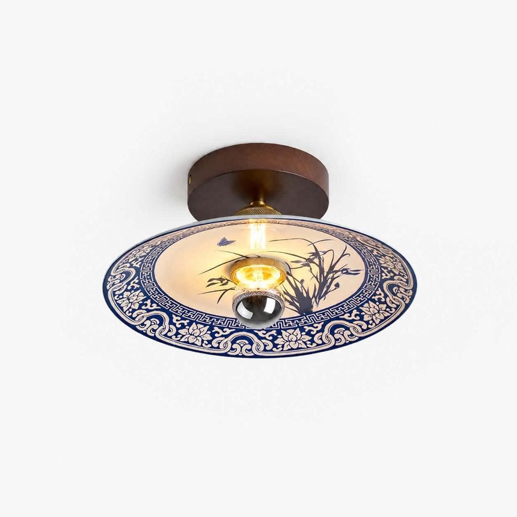This Clérachic ceiling light on a plain white backdrop, with a dark wood canopy and a blue-and-white ceramic shade.
