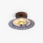 This Clérachic ceiling light on a plain white backdrop, with a dark wood canopy and a blue-and-white ceramic shade.