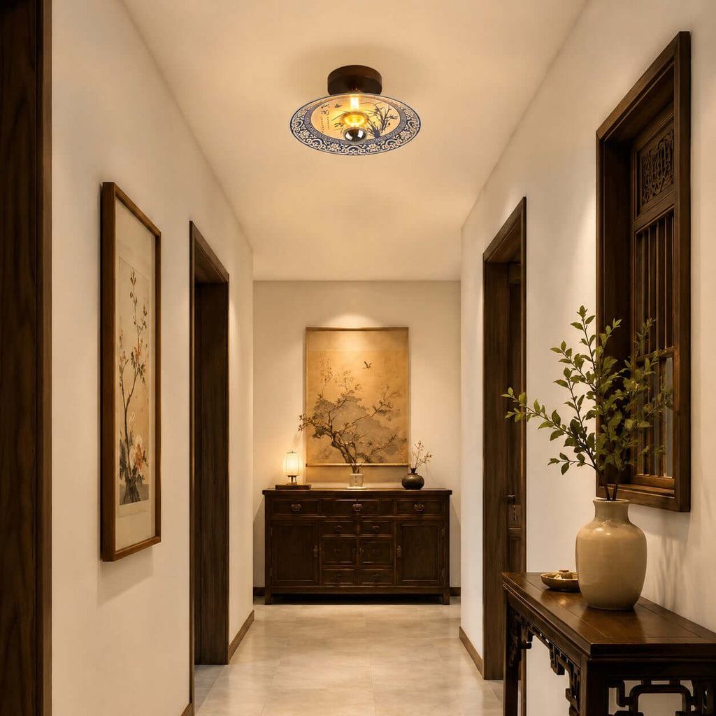 Down a long hallway, a Clérachic ceiling light sits above a carved sideboard and a framed floral print on the wall.