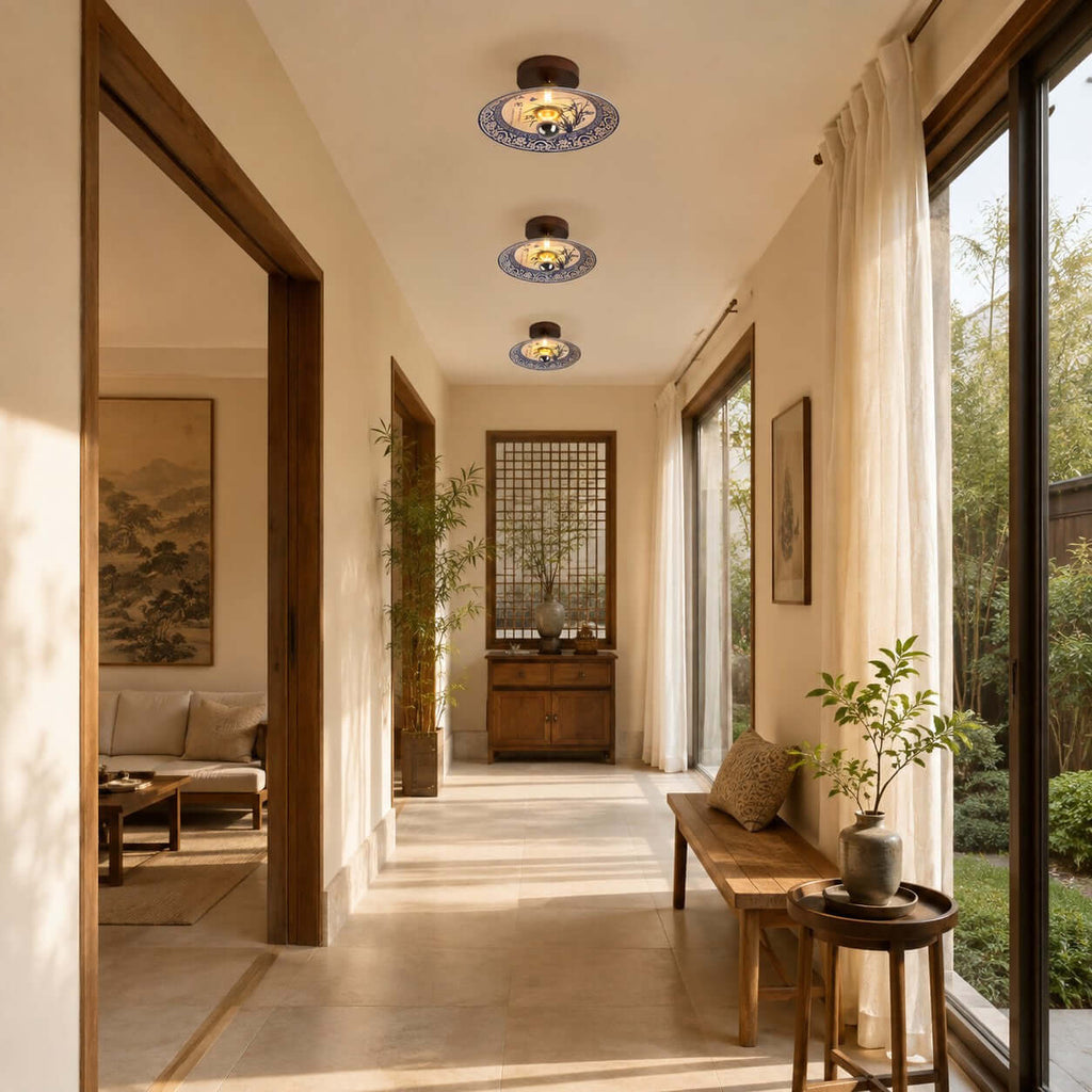 Three Clérachic ceiling lights run in a line down a long, bright hallway beside tall windows and a wooden bench.