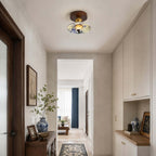 A Clérachic ceiling light with a patterned shade in a cream hallway with built-in cabinets and a blue-and-white vase.