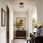 A Clérachic ceiling light above an arched entry with a dark sideboard and a large vase of white hydrangeas.