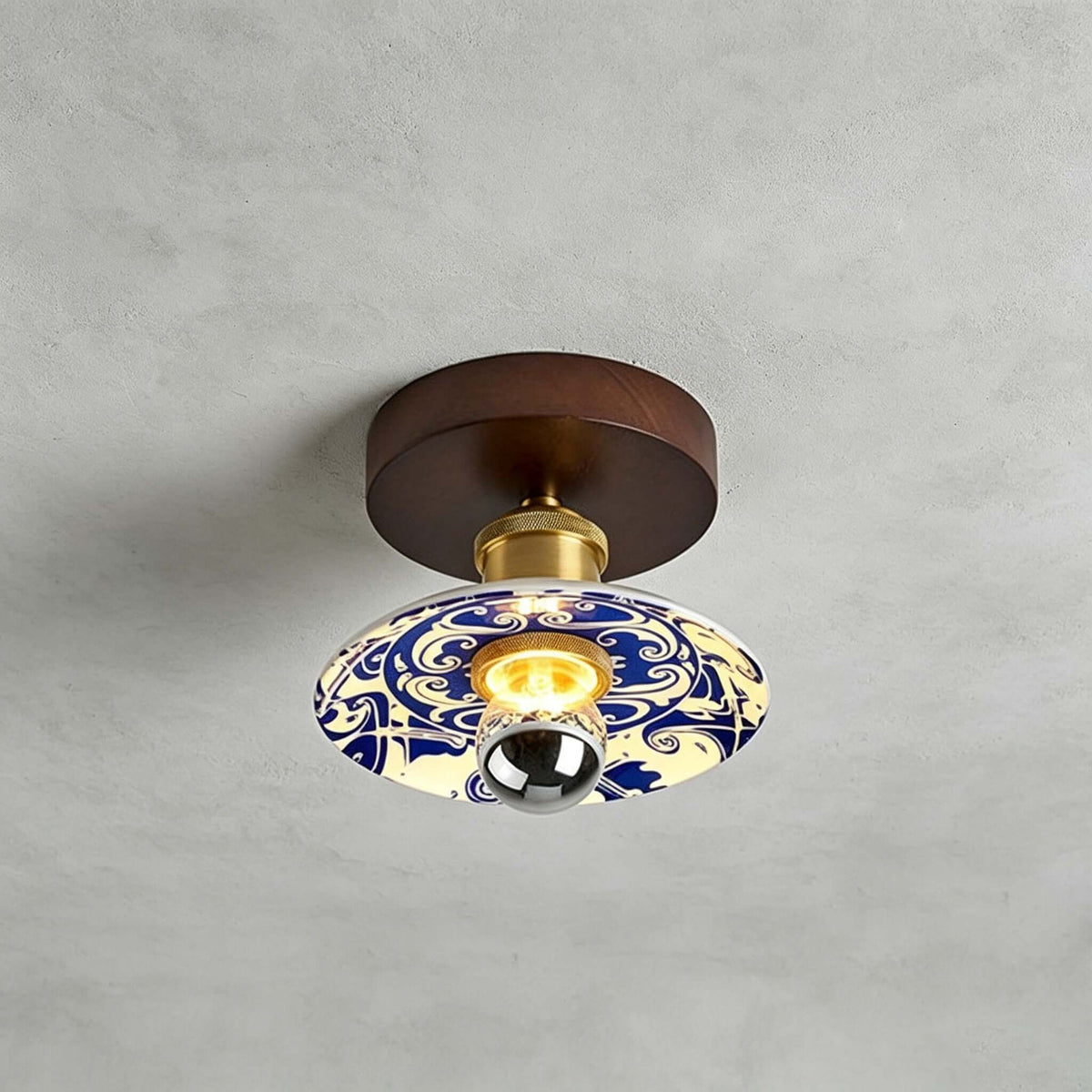 Close view of this Clérachic ceiling light on a grey concrete-look ceiling, with a swirling blue-and-white pattern on the shade.