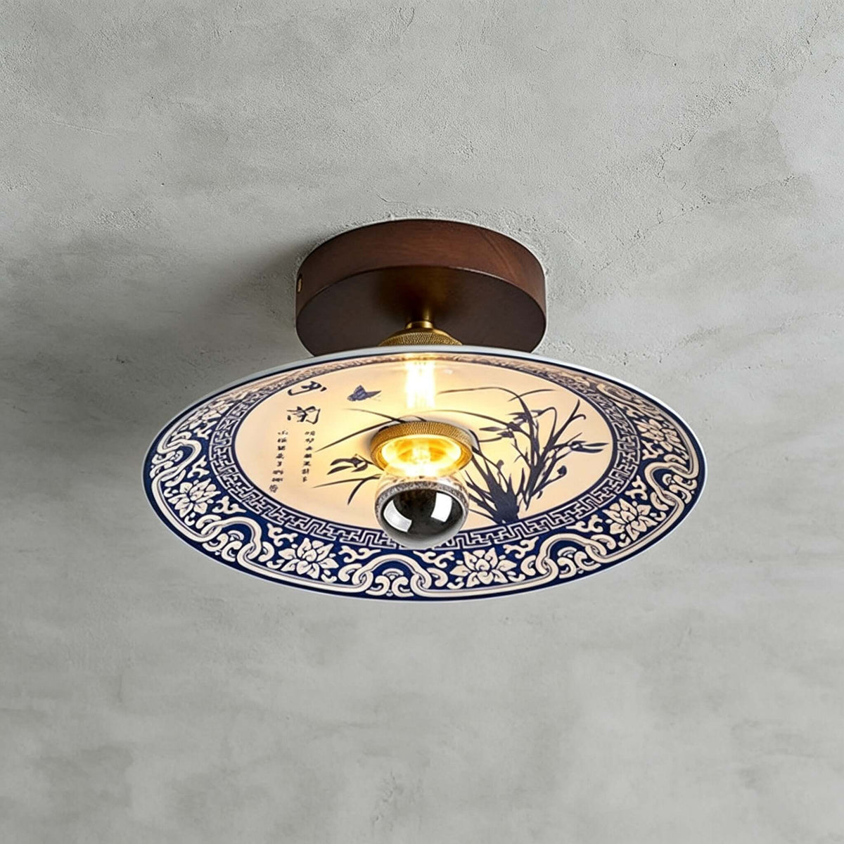 This Clérachic ceiling light shows an orchid painted in blue inside a border of blue-and-white scrollwork.
