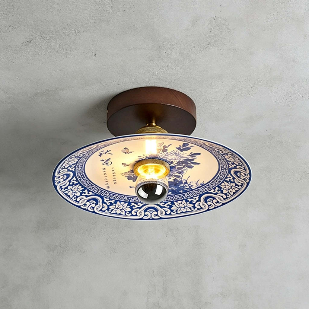 This Clérachic ceiling light shows a blue peony spray inside a scrolled blue-and-white border, under a dark wood canopy.