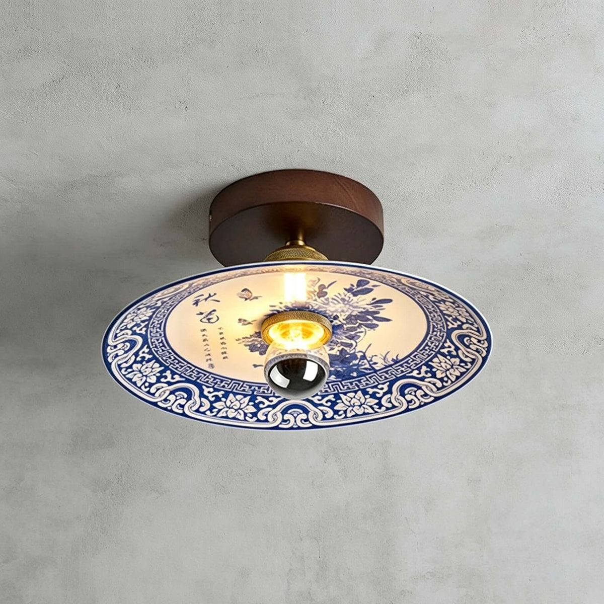 This Clérachic ceiling light shows a blue peony spray inside a scrolled blue-and-white border, under a dark wood canopy.