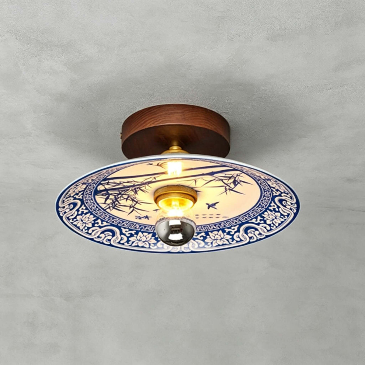 This Clérachic ceiling light shows bamboo painted in blue on its shade, ringed by a blue-and-white patterned border.