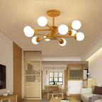 Wood and white Clérachic ceiling light with many glass globes, lit above a living area with slatted wooden screens and a pale sofa.