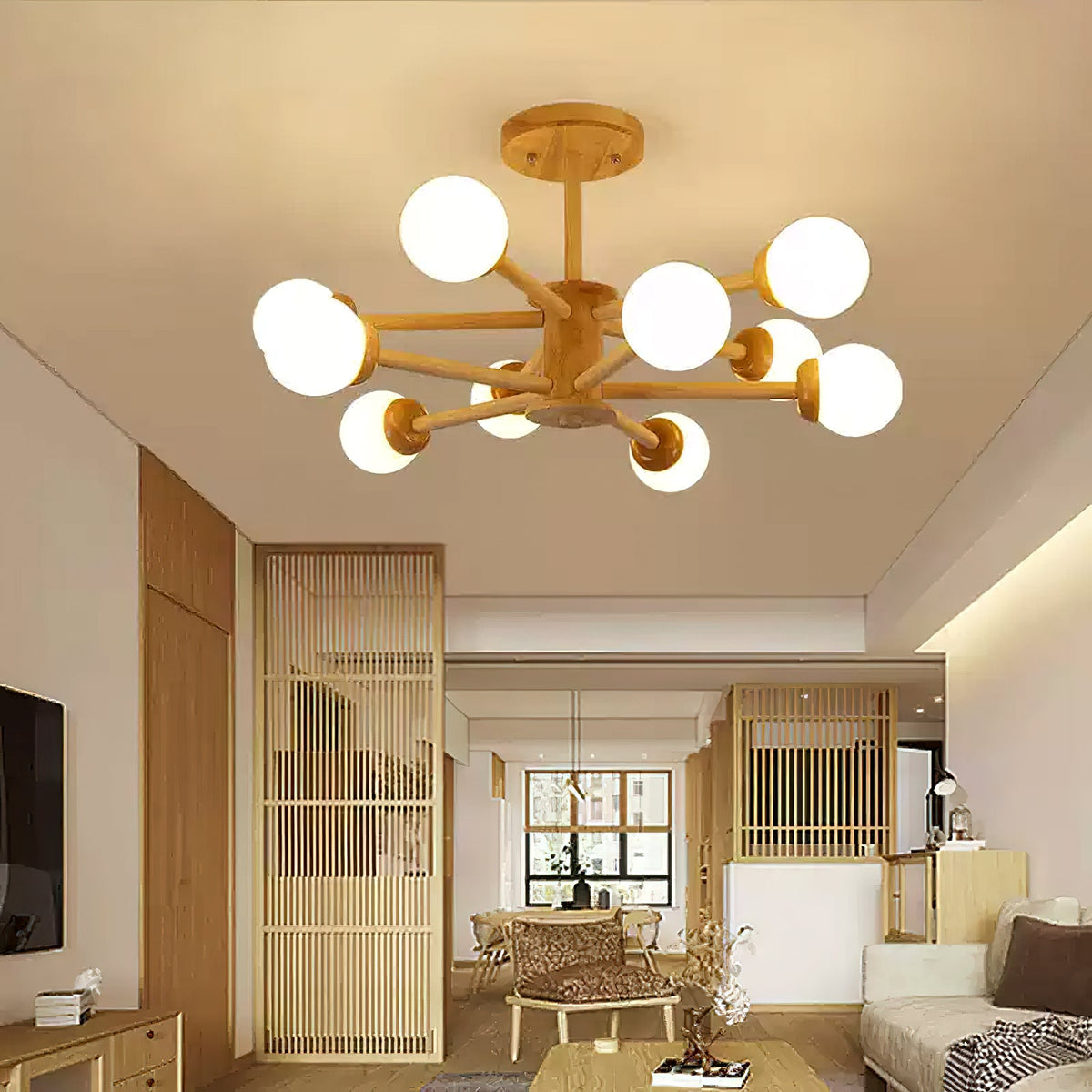 Wood and white Clérachic ceiling light with many glass globes, lit above a living area with slatted wooden screens and a pale sofa.
