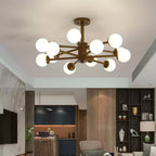Walnut and white ceiling light from Clérachic, with a dozen lit globes, in an open-plan room with a kitchen island and dark shelving.