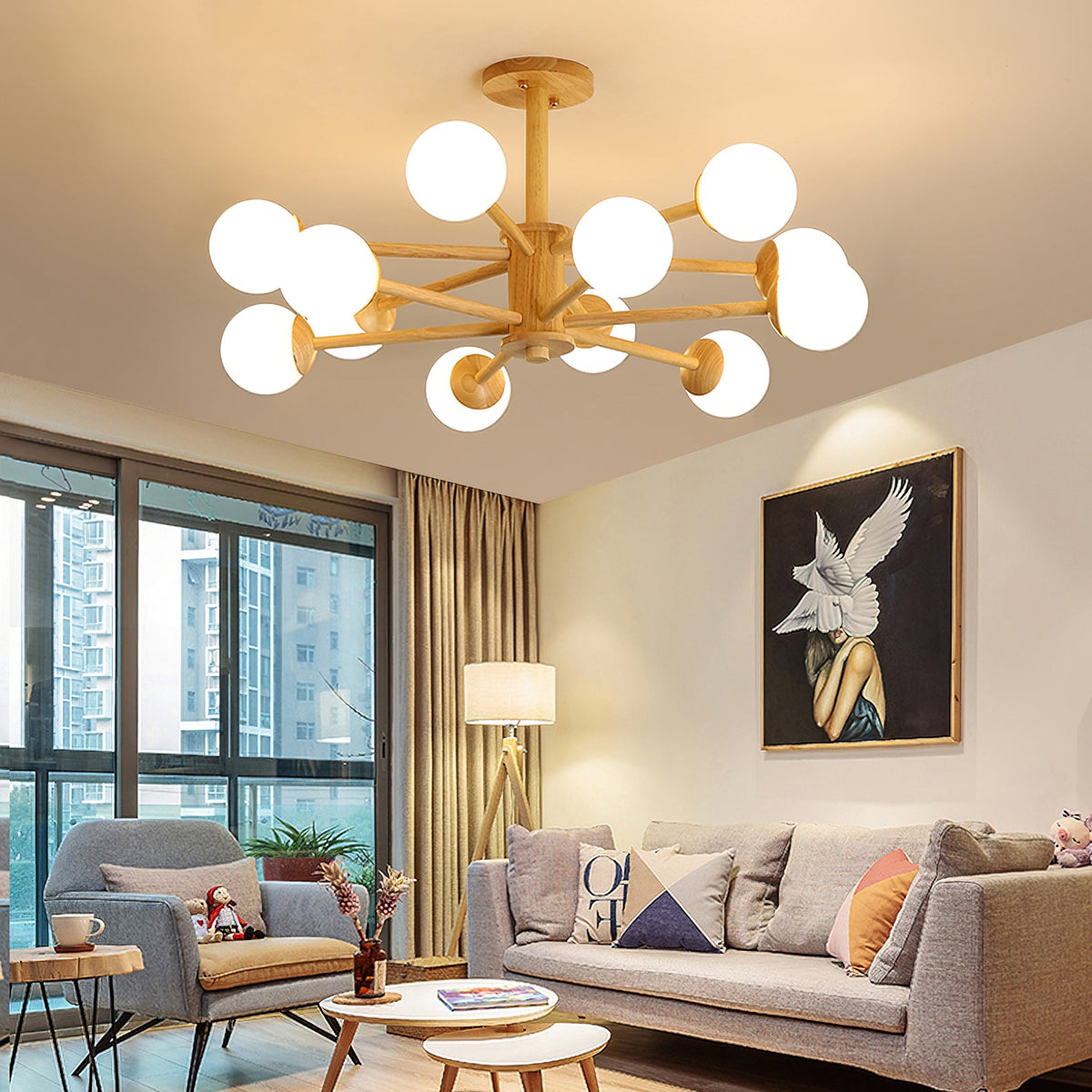 Light wood Clérachic ceiling light with lit white globes above a living room with a grey sofa, a floor lamp and a large framed print.