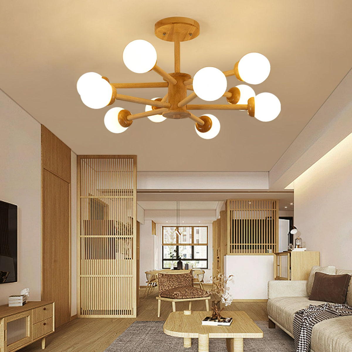 Lit globes on the pale wooden arms of this Clérachic ceiling light, in a living room with a low wooden coffee table and slatted screen.
