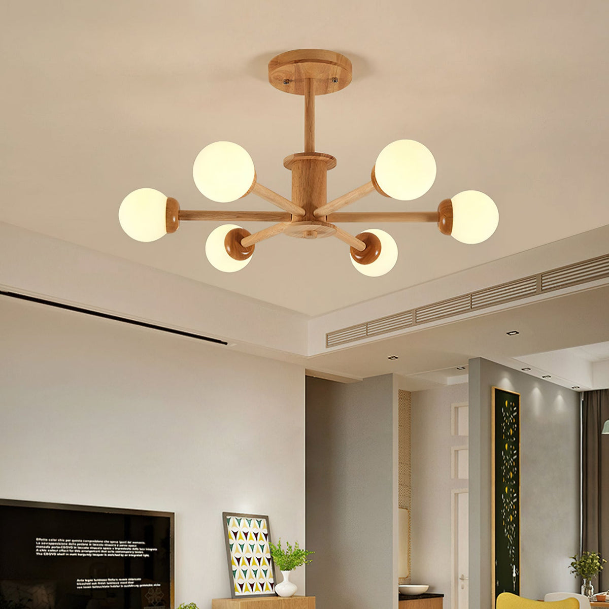 Six-globe ceiling light from Clérachic in a light wood finish, lit warm in a living room with a television and a framed print.