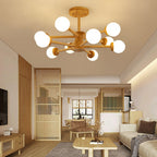 Wood and white Clérachic ceiling light with its globes glowing, above a living room with a slatted partition and a woven rug.