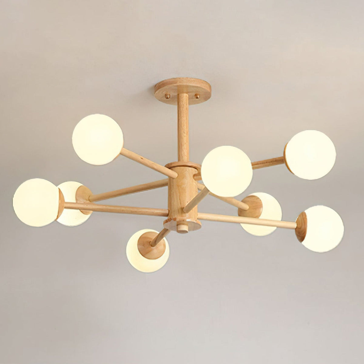 Light wood Clérachic ceiling light with eight white globes on long arms around a wooden hub, against a grey ceiling.