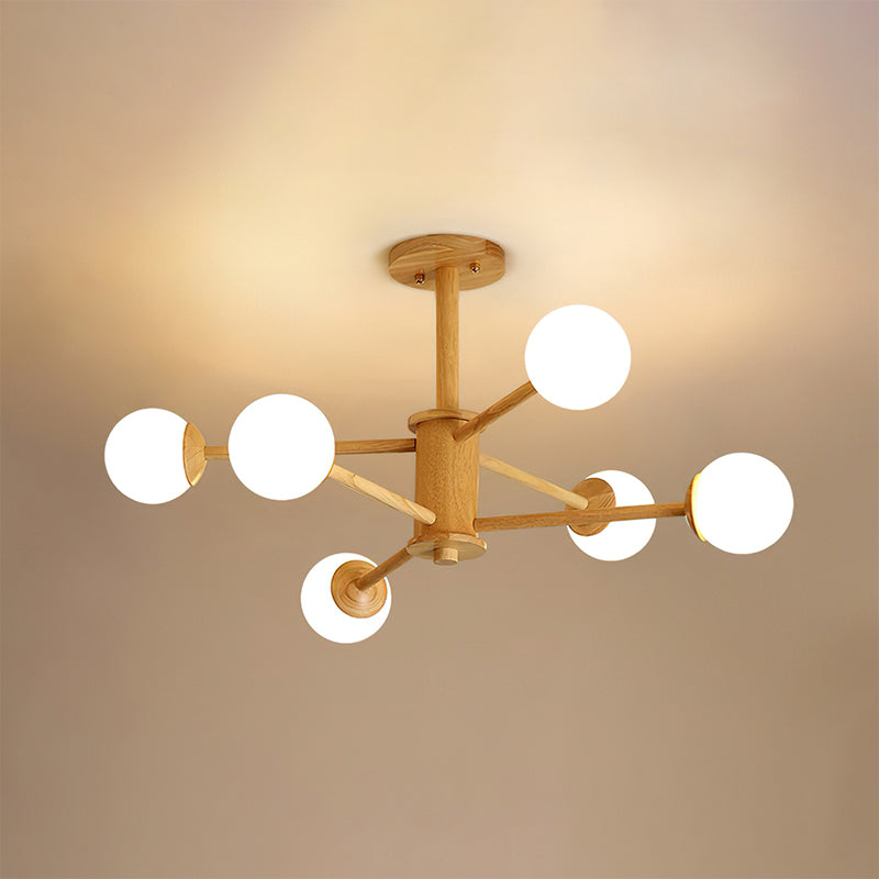 Six-globe ceiling light in light wood from Clérachic, glowing against a ceiling washed in warm light.