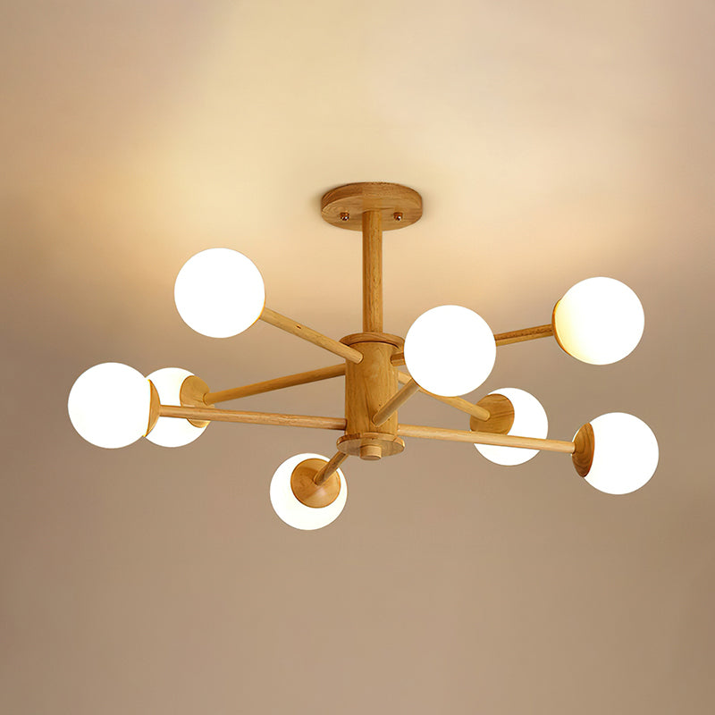 Eight globes on straight wooden arms, this light wood Clérachic ceiling light is lit against a warm beige ceiling.