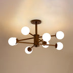 Dark walnut Clérachic ceiling light with eight white globes on long thin arms, lit against a golden ceiling.