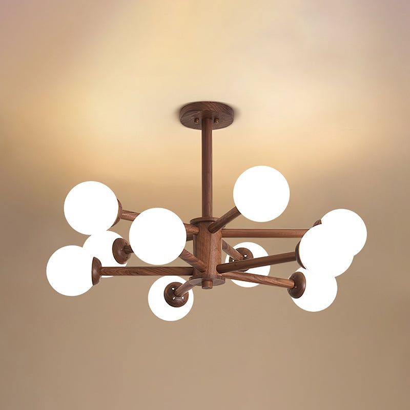 Walnut ceiling light from Clérachic with white globes bunched around a dark wooden stem, against a warm ceiling.