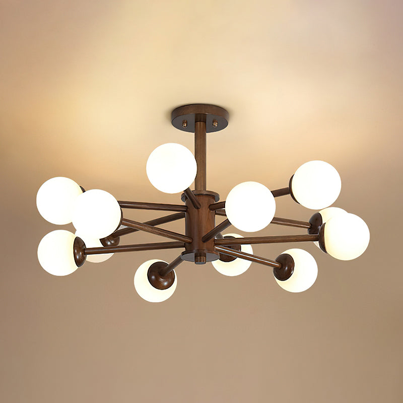 Twelve-globe walnut and white Clérachic ceiling light with layered dark arms, lit against a honey-toned ceiling.