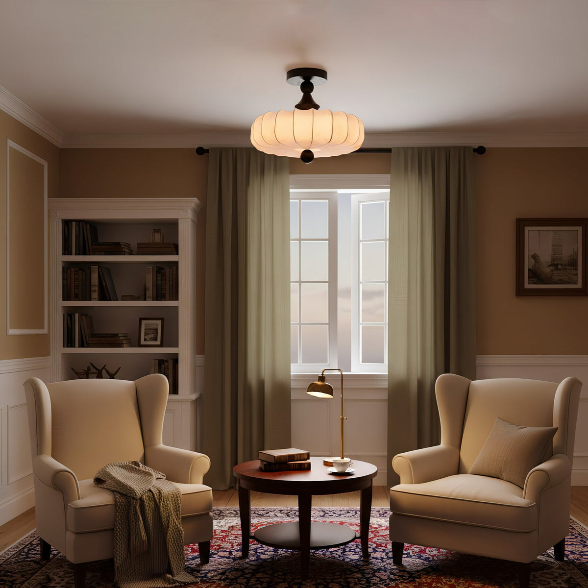 A lit Clérachic ceiling light with a beige pleated shade hangs in a warm study with two wing chairs, olive curtains and a patterned rug.