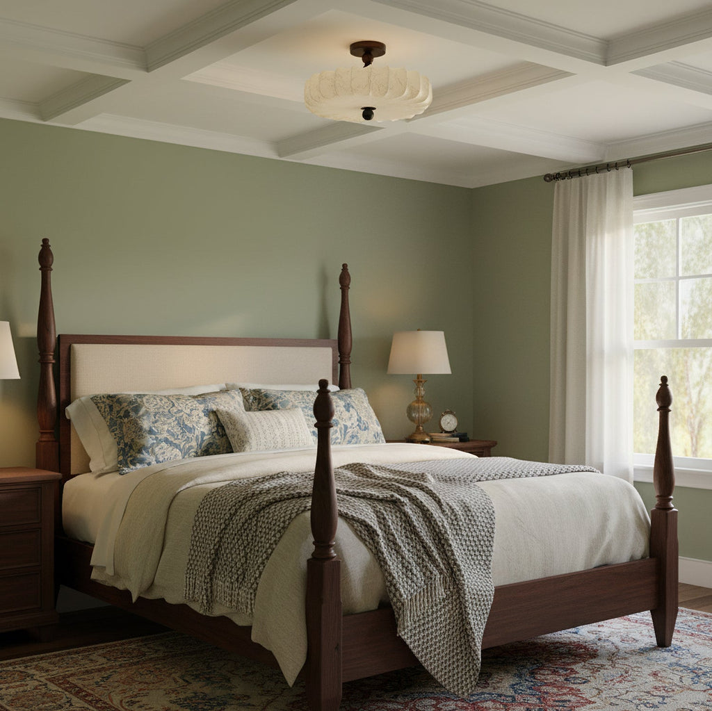 A pleated beige Clérachic ceiling light hangs from a coffered ceiling above a four-poster bed, in a sage-green bedroom.