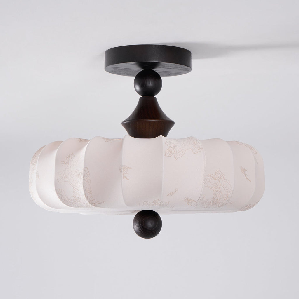 An unlit Clérachic ceiling light on a grey backdrop, showing the pleated beige drum, turned dark stem and ball finial below.