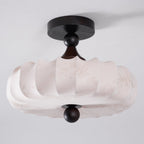 Seen from below at an angle, this Clérachic ceiling light shows its faint printed floral pattern and scalloped lower edge on the beige shade.