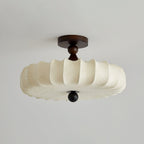 Switched off, this Clérachic ceiling light shows its cream fabric shade with a faint printed pattern, a dark canopy and a round wooden finial.